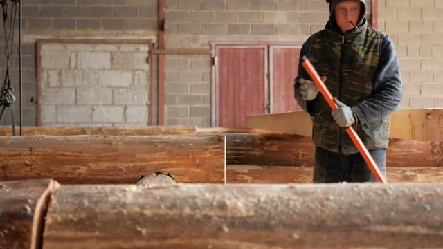 Builder construction check bubble level wooden logs future home. Pencil in the teeth for marking