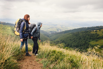 Fototapeta na wymiar Couple of travelers with backpacks looking on the hills