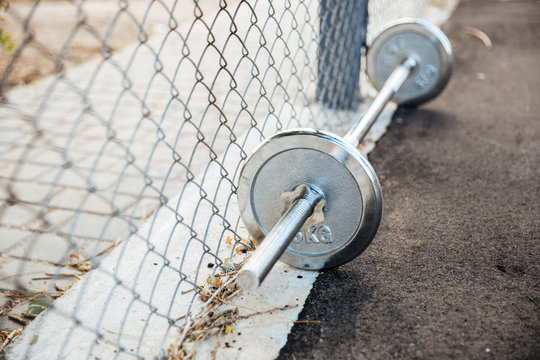Dumbbells with weights lying on sports ground