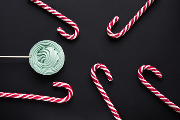 Christmas candy cane, mint marshmallow on black background. Christmas background. Top view and copy...