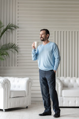 Happy optimistic man enjoying his tea