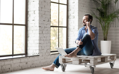 Positive good looking man speaking on the phone