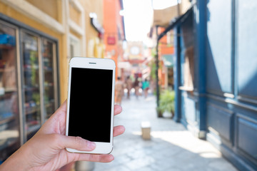 Hands woman are holding touch screen smart phone,tablet on blurred old building background.