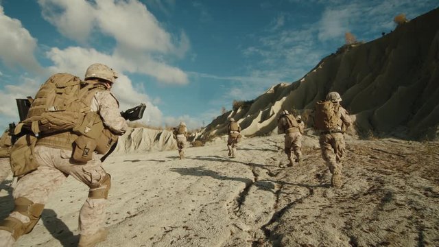  Follow Shot of Squad of Soldiers Running Forward During Military Operation in the Desert. Slow motion. Shot on RED EPIC Cinema Camera in 4K (UHD).