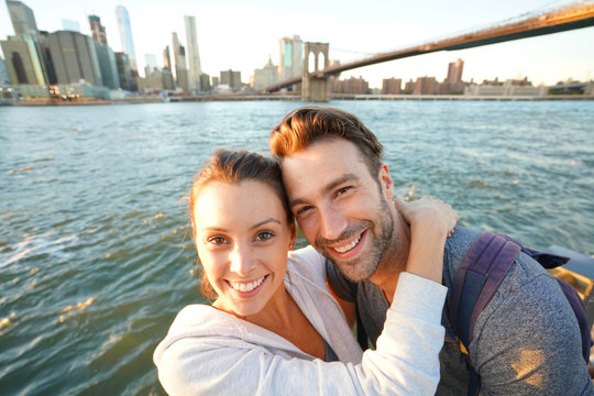 Couple embracing each other, Brooklyn bridge in background