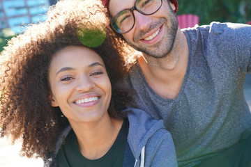 Cheerful trendy couple sitting in park in the morning