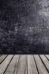 Old wooden table in front of black chalkboard vintage wall. Blac