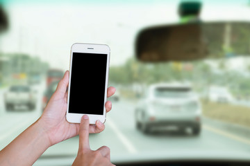 Hands woman are holding touch screen smart phone; tablet on blurred man driving car background.