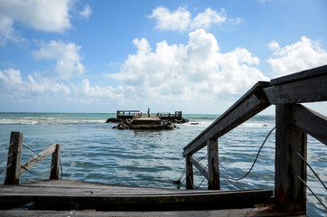 Dettaglio del pontile di legno sul mare mosso con le onde  che si infrangono Lido di Ostia Roma...