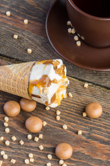 Ice cream cone on wooden table with cup
