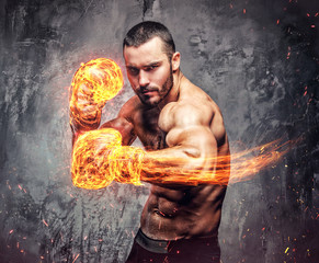 Shirtless aggressive fighter with burning boxer gloves.