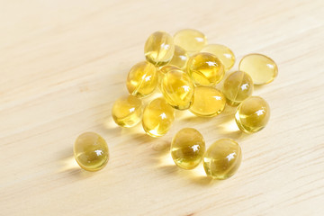 Cod liver oil omega 3 gel capsules isolated on wooden background. Vitamin D capsuls. dietary...