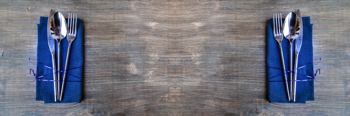 Concept of simple organic food - laconic design cutlery set on rustic wooden table and linen tissue. Top view. Wide panoramic image. 