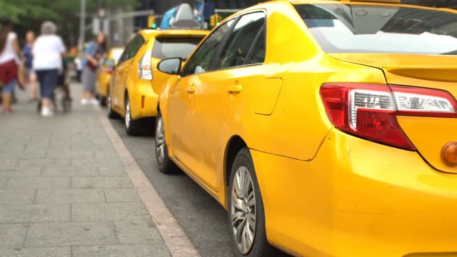 Yellow taxi vehicles waiting for passengers in New York City, wide angle with noticeable DOF effect, no recognizable people or logos.
