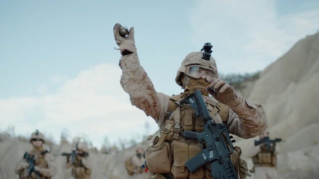 Soldier Throwing a Granade during Combat in the Desert. Slow Motion.