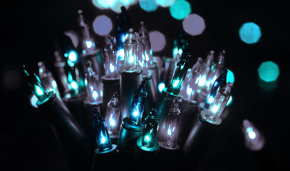 Close up Christmas, New Years garland retro cold toned color lights with bokeh dark background