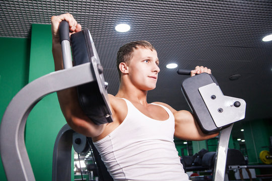 Athlete doing chest exercise on machine in gym