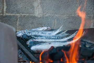 Flames and fish on grill.