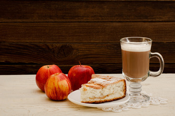 Apple pie, cappuccino and ripe apples on a wooden background