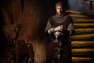 Medieval knight in ancient castle interior.