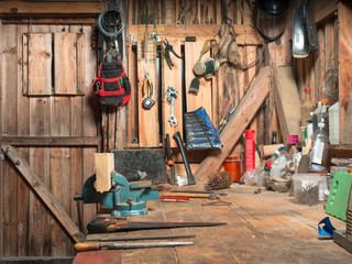 Image of a wooden table with a vise, and set them on the board against lying and hung on the walls of instruments inside the workshop rooms