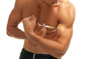 Muscular man injecting steroids on white background