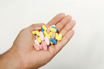 Male hand holding drugs on color background