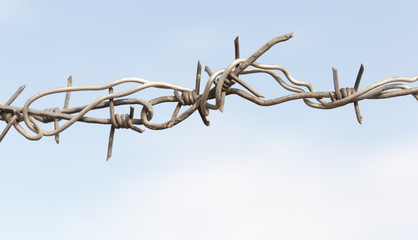 Barbed wire on a wooden post against blue sky