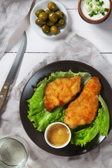 Chicken schnitzel and lettuce with olives