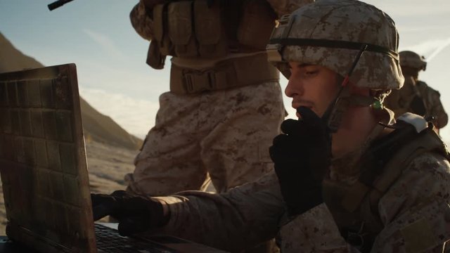 Soldiers are Using Laptop Computer and Radio for Communication During Military Operation in the Desert