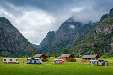 Fototapeta na wymiar Norwegian camping houses under the high mountains of Eidfjord.