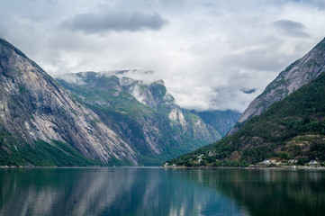 Norway fairytale fjord landscape with mirror water and steep mountains.