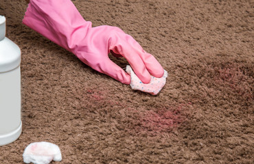 Nail polish stain cleaning with special chemical liquid. Carpet cleaning. Early spring cleaning or regular clean up. Inscriptions from the bottle is removed.