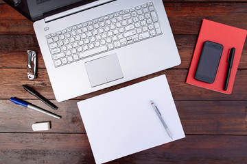Workplace , blank sheet of paper with a pen and .mobile phone and laptop on a wooden background - Mock up