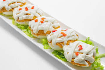 Stuffed eggs with tuna, tomato, mayonnaise and red pepper on whi