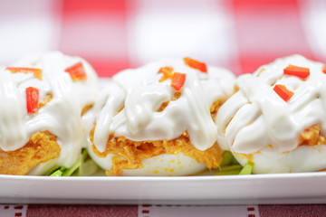 Close up of Stuffed eggs with tuna, tomato, mayonnaise and red p