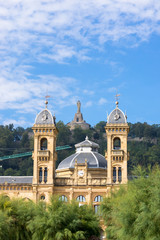 Towers of the city hall of Donostia San Sebastian. The city council is located in the premises of the former casino of the city. In the background on the mountain Urgull, the sculpture of Jesus Christ