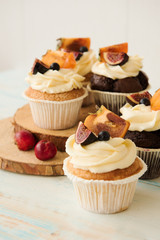 Cupcakes with Fig, persimmon and cream cheese on a wooden table