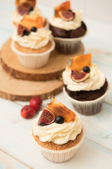 Cupcakes with Fig, persimmon and cream cheese on a wooden table