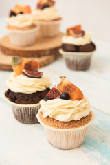 Cupcakes with Fig, persimmon and cream cheese on a wooden table