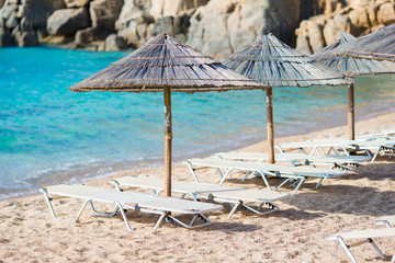 Beach wooden chairs and umbrellas for vacations on beach in Greece
