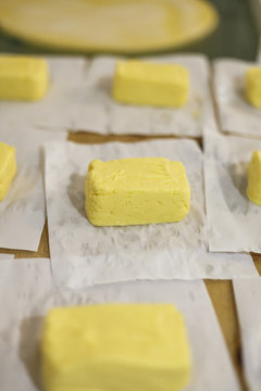 Frische St&uuml;cke von guter Alm Butter werden eingepackt.