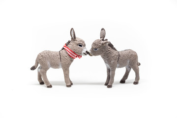 Two toy donkeys kissing,  isolated on white background