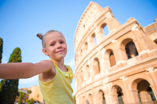 Little girl taking selfie in front of Colosseum in Rome, Italy.