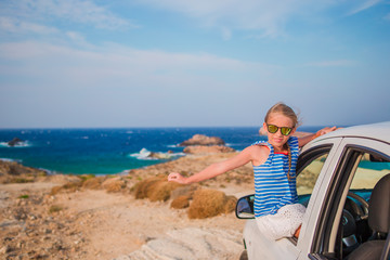 Little girl on vacation travel by car background amazing sea view