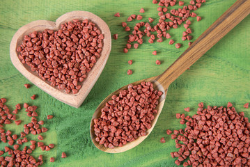 Annatto seeds in wooden spoon