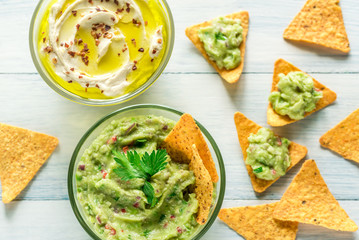 Bowls of hummus and guacamole with tortilla chips