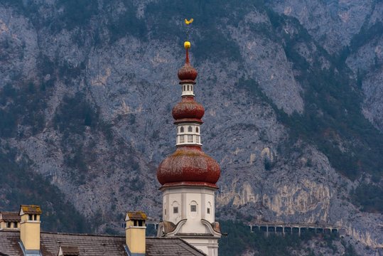 Kirchturm mit Felswand im Hintergrund
