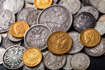 Gold and silver coins of the Russian Empire in the background ko