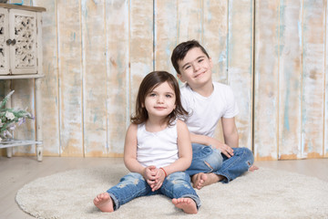 Brother and sister embracing together on the floor